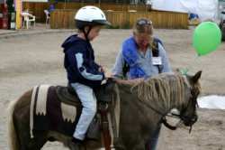 This young man enjoyed his ride on a  tiny pony